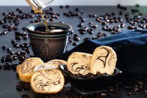 Kahlúa Coffee Swirl Cookies placed on table and in a small bowl with cup of coffee