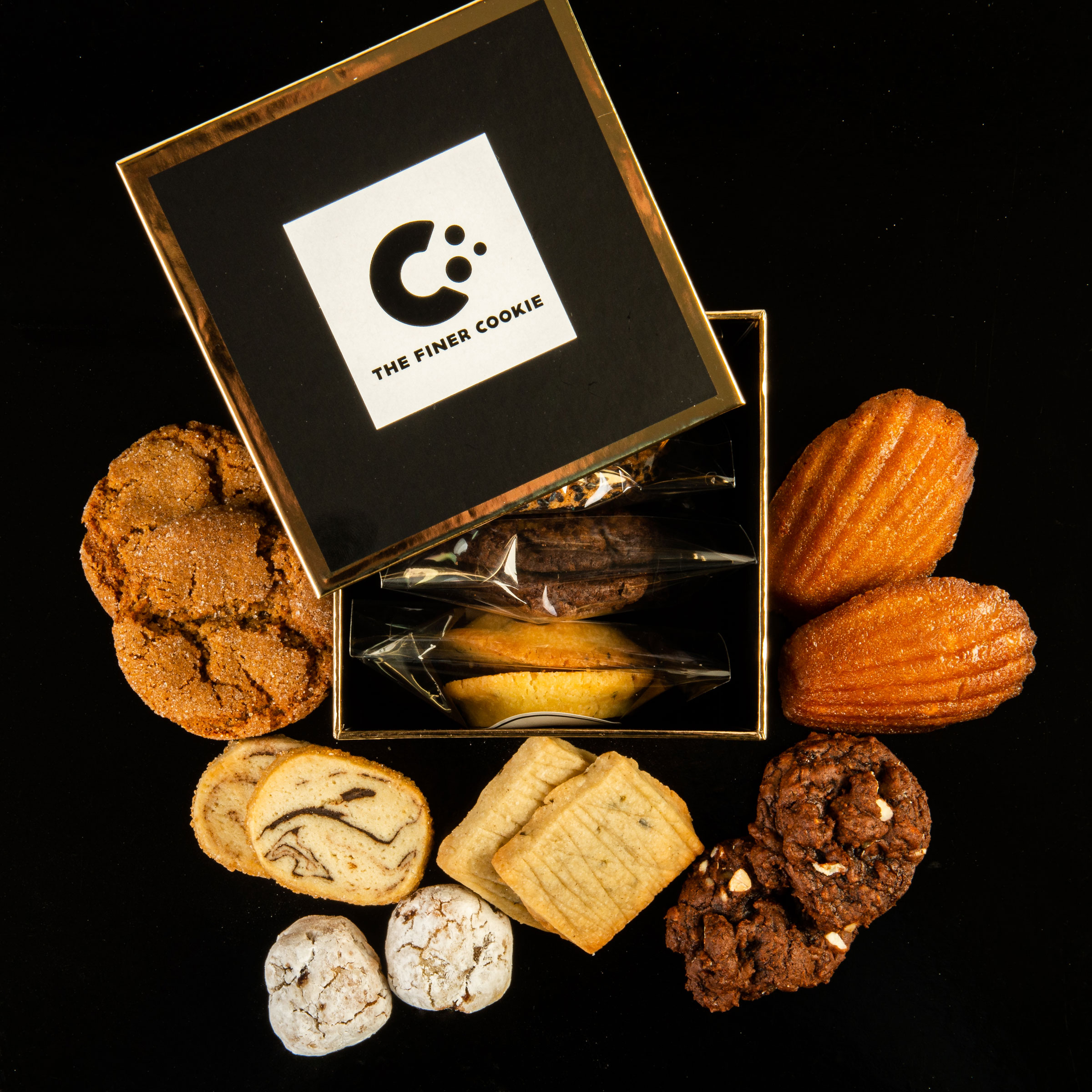 Individually Wrapped Cookies in Signature Gift Box placed on a table with cookies placed around the box.