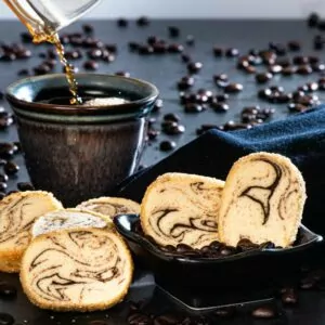 Kahlúa Coffee Swirl Cookies placed on table and in a small bowl with cup of coffee