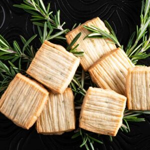 Rosemary shortbread with vodka and cardamom placed on table with fresh rosemary.
