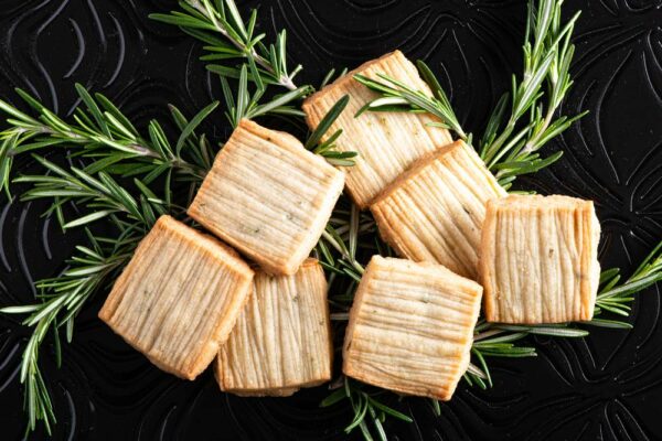 Rosemary shortbread with vodka and cardamom placed on table with fresh rosemary.