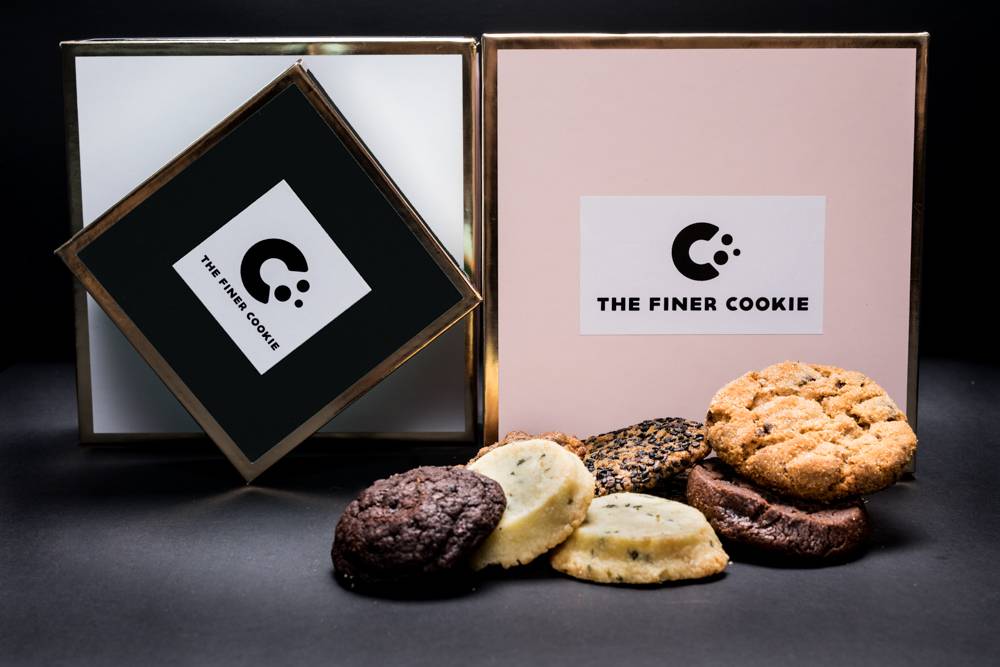 Signature Gift Boxes placed on a table with cookies placed in front.
