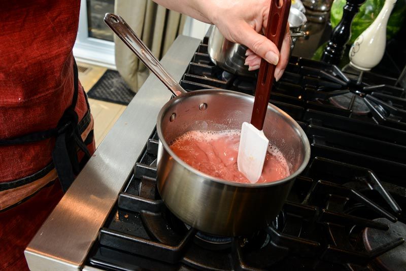Stirring the cranberry curd until it thickens.