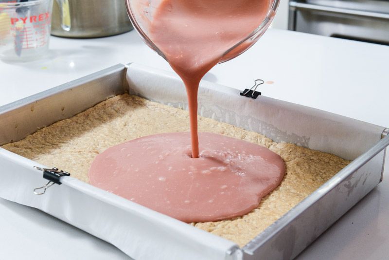 Pouring the cranberry curd into the baked walnut shortbread crust.