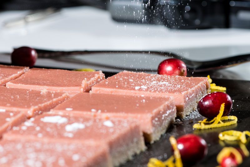 Dusting powdered sugar onto the cranberry curd.