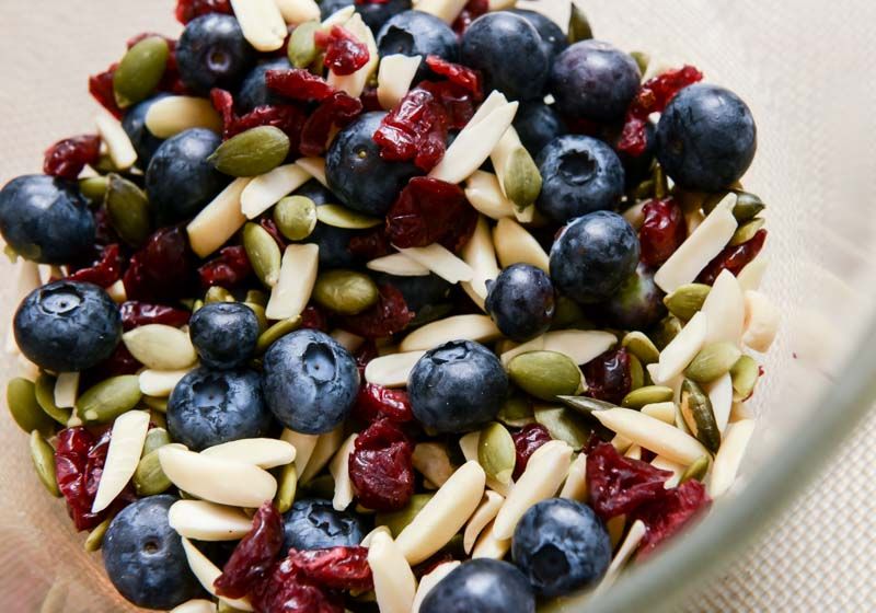 A mix of blueberries, almonds, dried cranberries and pumpkin seeds.