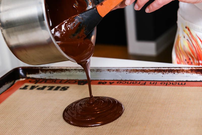 Pouring the melted chocolate on a silicone mat.