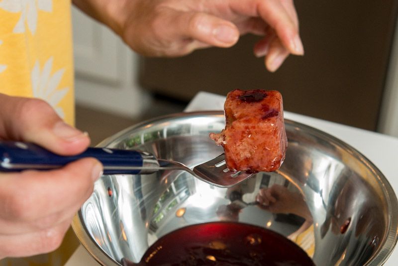 Coating the cake with cherry jam.