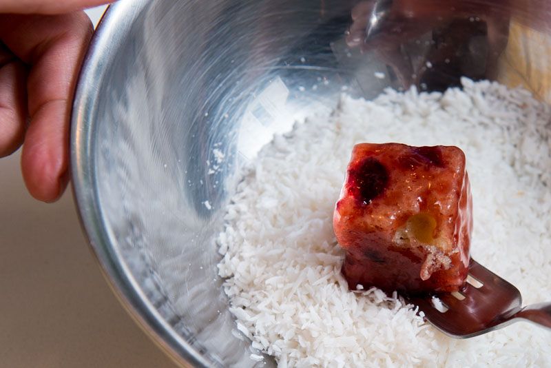 Coating the cake in unsweetened coconut.