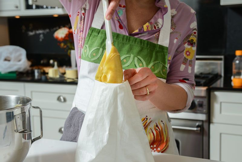 Filling the pastry bag with choux pastry.