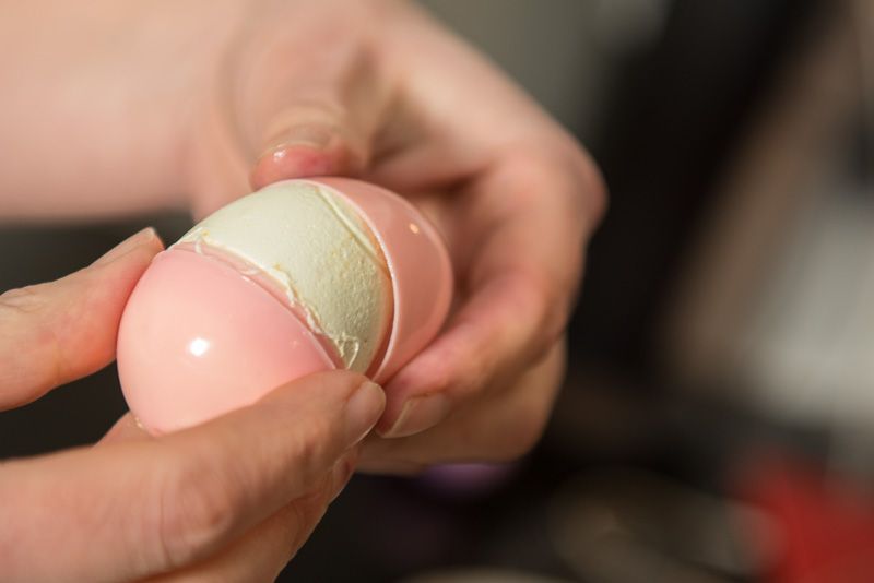 Opening the plastic egg to see the set marshmallow.