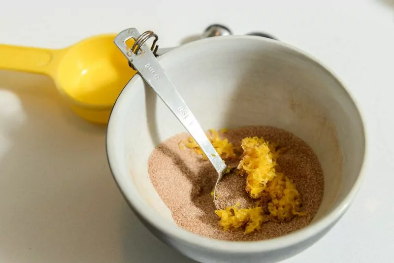 Add zested lemon to the cinnamon sugar mixture. You’ll roll the cookie dough in this mixture before baking.