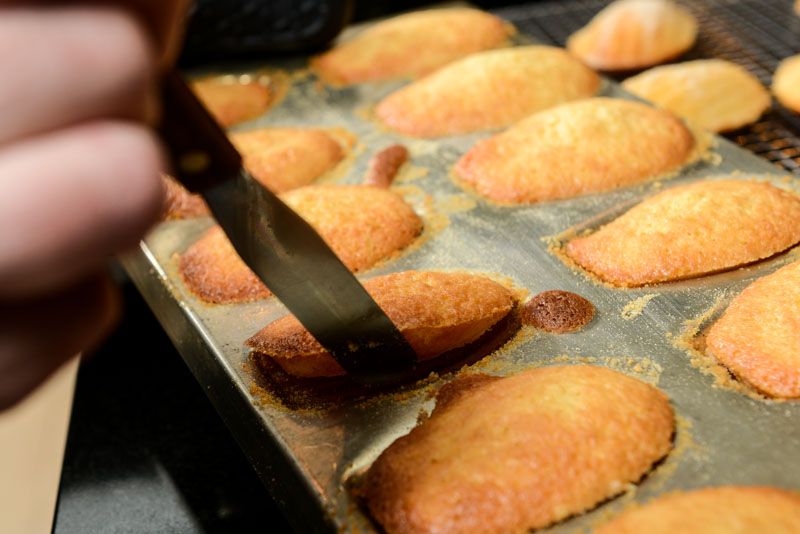 When all the madeleine cookies are released, flip the mould and let the cookies drop onto the cooling rack. Alternately, lift each cookie and place them on the cooling rack.