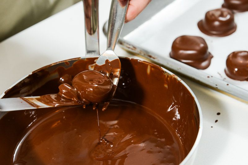 Use a fork and an offset spatula to lift the peppermint patty from the melted chocolate.