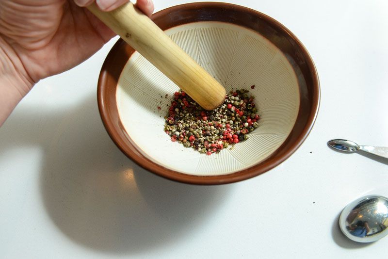 Crushing the 4 different peppercorns.