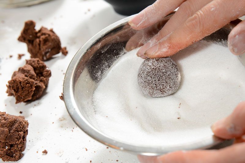 Roll the crinkle cookies in granulated sugar before rolling in powdered sugar.