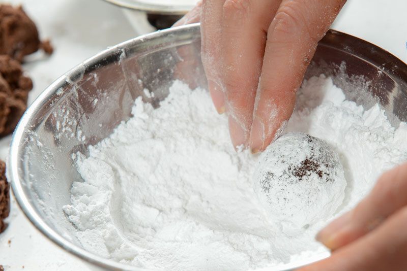 Rolling a heavy layer of powdered sugar after the granulated sugar.