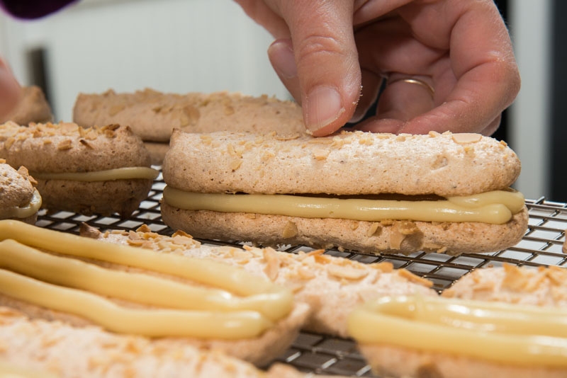 Making the sandwich with the almond lady fingers and white chocolate filling.