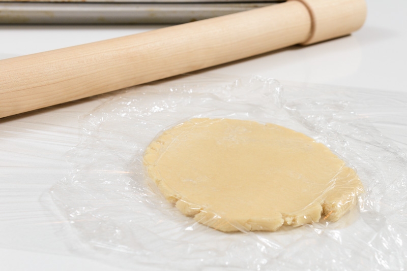 Rolling the cookie dough with a sheet of plastic prevents cracking.