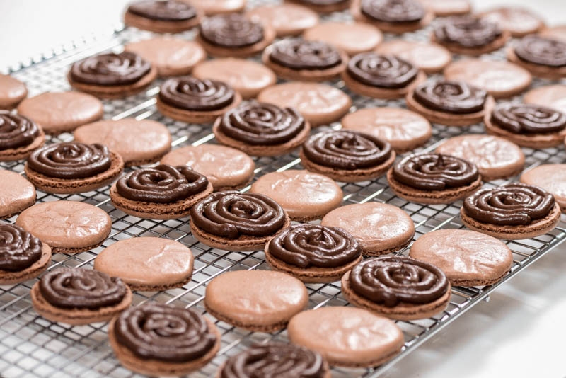 Chocolate macaron shells with the chocolate ganache filling.