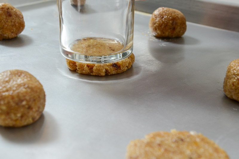 A flat bottomed glass evenly presses the cookie dough.