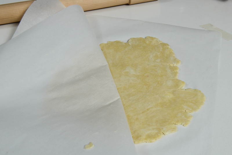 Peeling the parchment to prevent sticking. Notice how the cream cheese continues to streak throughout the dough.