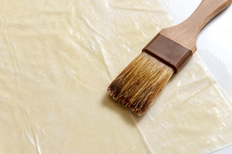 Brushing phyllo dough with olive oil.