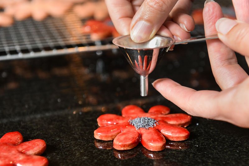 Remove your finger quickly to release the poppy seeds all at once.