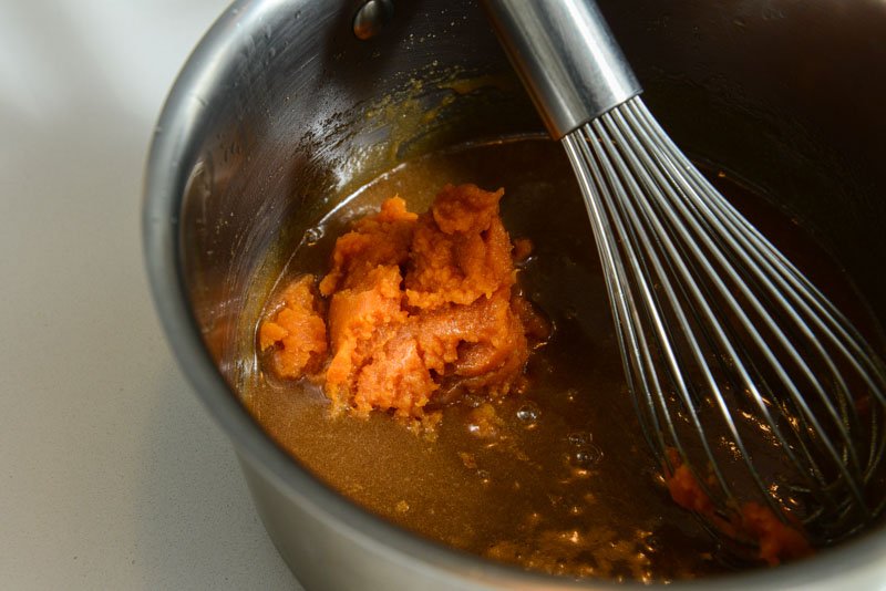 Adding pumpkin to the butter and sugar mixture.