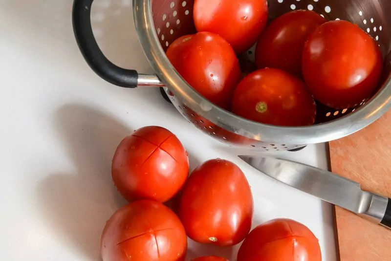 Making x’s in the bottom of the tomatoes.