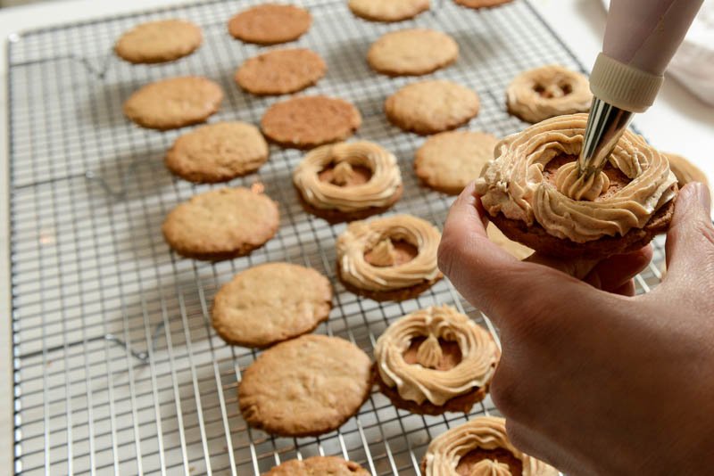 Pipe the peanut butter cream on half the cookies.