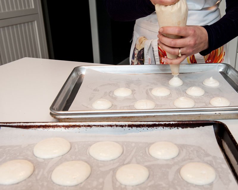 Piping the macaron batter and letting it settle.