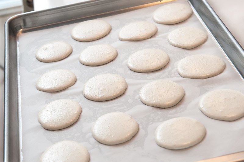 Piped and settled macaron batter.
