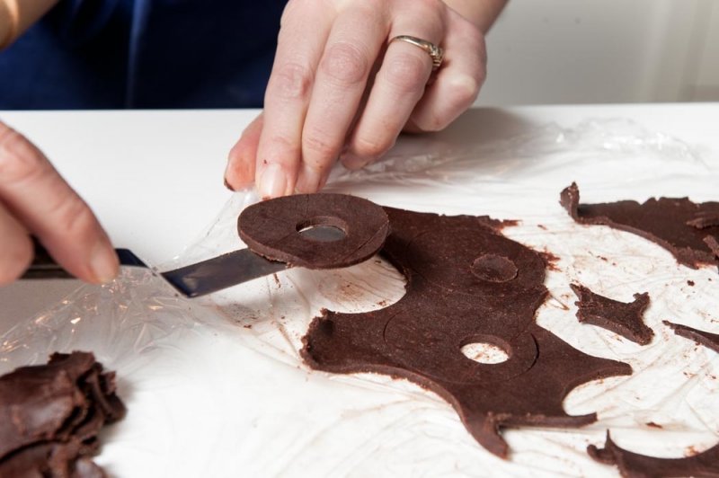 Lifting the cut chocolate shortbread onto a prepared tray.