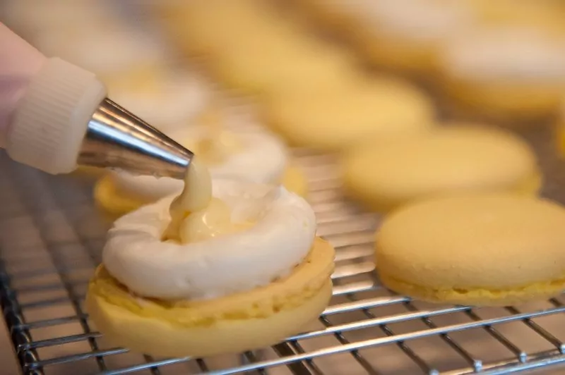 Filling the macaron with lemon curd.