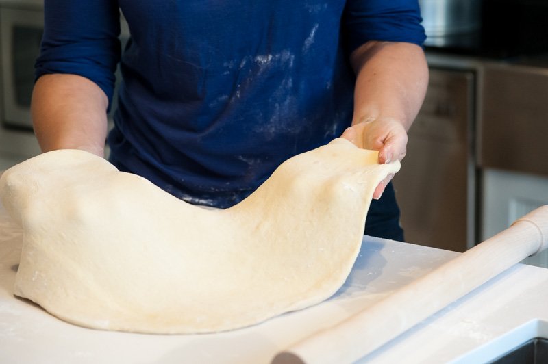 Rolling the brioche dough and adding flour underneath.
