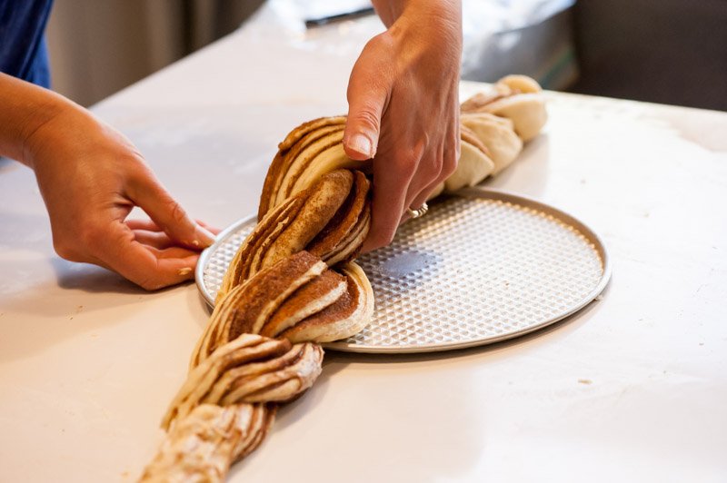 Sliding the springform base underneath the brioche rope.