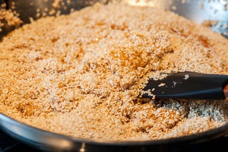 Stirring the sesame seeds into the hot sugar.