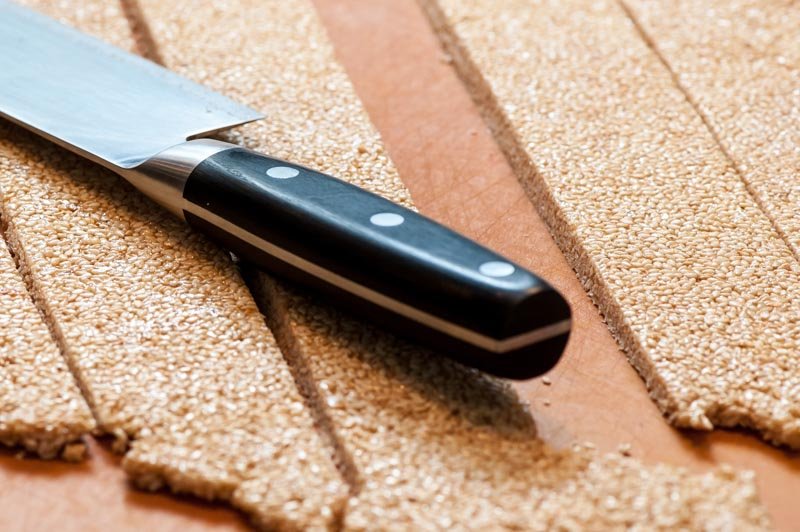 Cutting the warm sesame seed nougat.