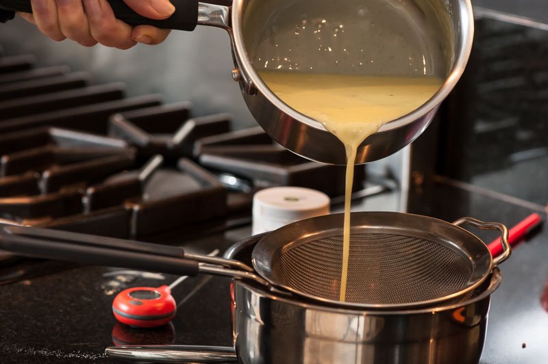 Straining the custard into the chopped chocolate.