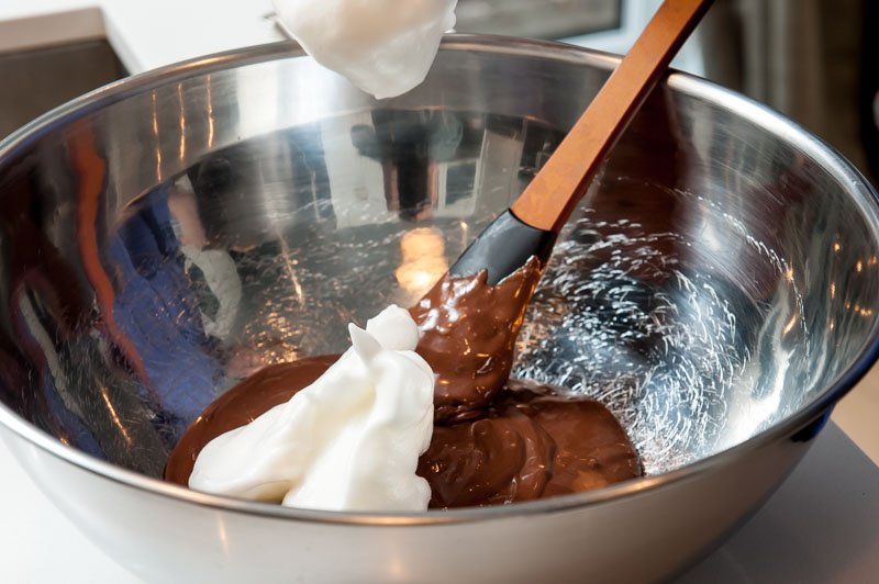 Adding the egg whites to the chocolate custard.