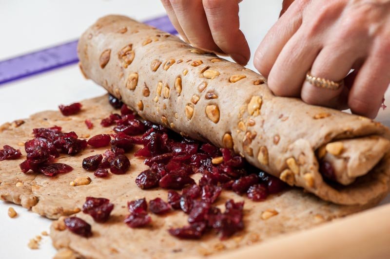 Rolling up the cranberries into the bread dough.