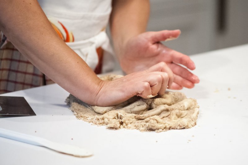 Kneading the dough until the ingredients are well blended.