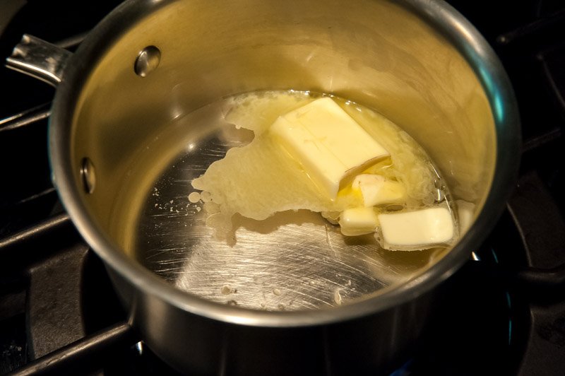Melting the butter in the water and bringing it to a boil.