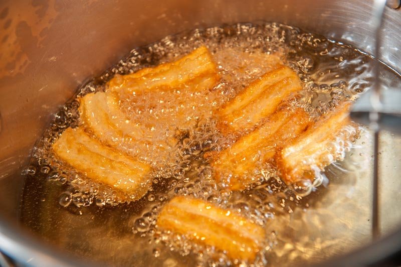 The churros sizzling to golden brown.
