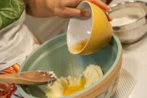 Adding the egg to the butter and sugar.