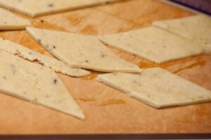 The dough being cut into diamonds.