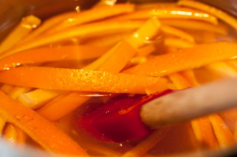 Simmering orange rinds in the sugar syrup.