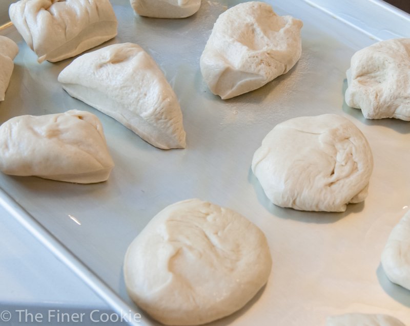 The dough pieces being rolled and flattened.