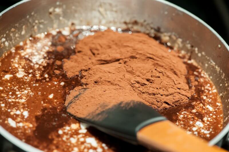 Adding the cocoa to the butter and chocolate.